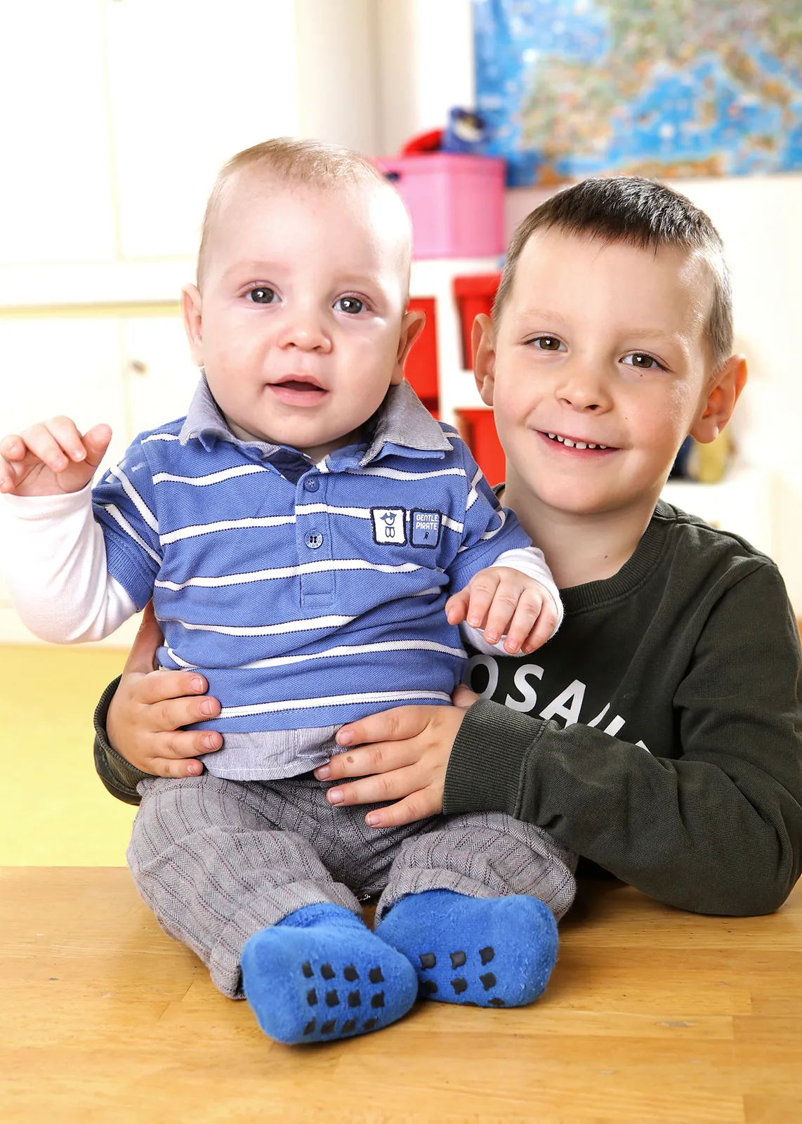 Großer Bruder hält seinen kleinen Bruder auf dem Schoß